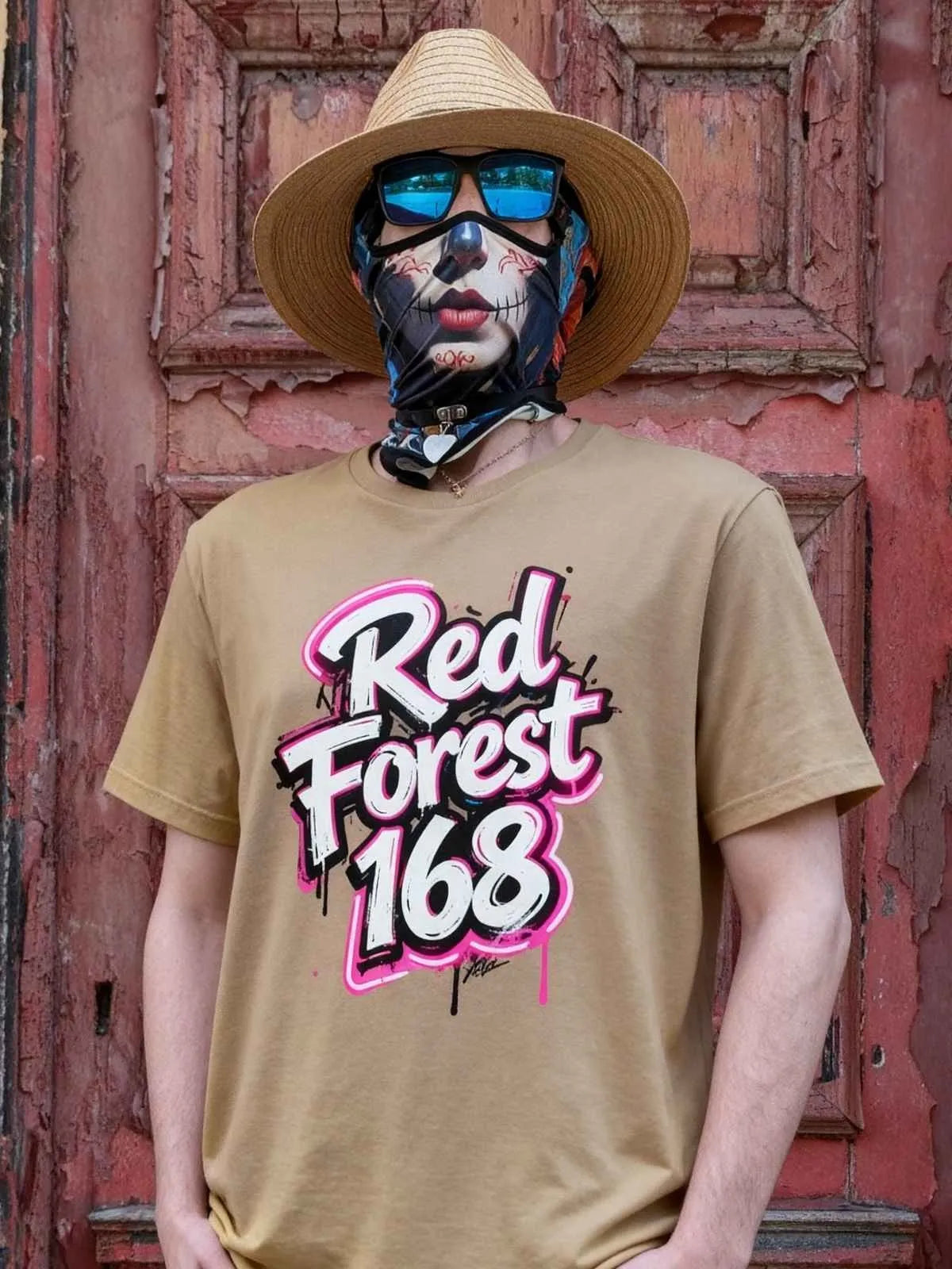 Person wearing a tan shirt with 'Red Forest 168' design, sunglasses, and a hat against a rustic wall.