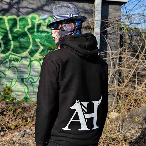 The Sun Walker wearing an Albert Harry AH Minimal Dire Wolf Clan Royal Seal hoodie in a Manchester graffiti location.