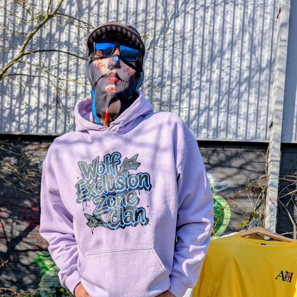 The Sun Walker wearing Wolf Exclusion Zone Clan lavender hoodie in Manchester graffiti location.